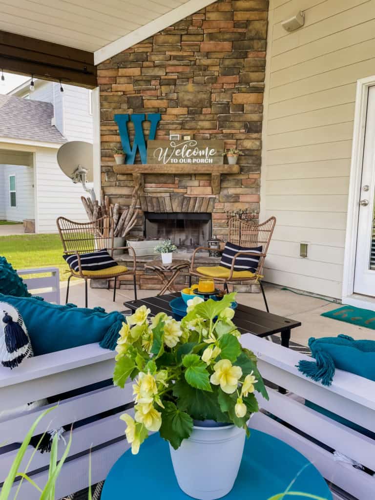Back porch decor with brick fireplace and grey and blue decor.