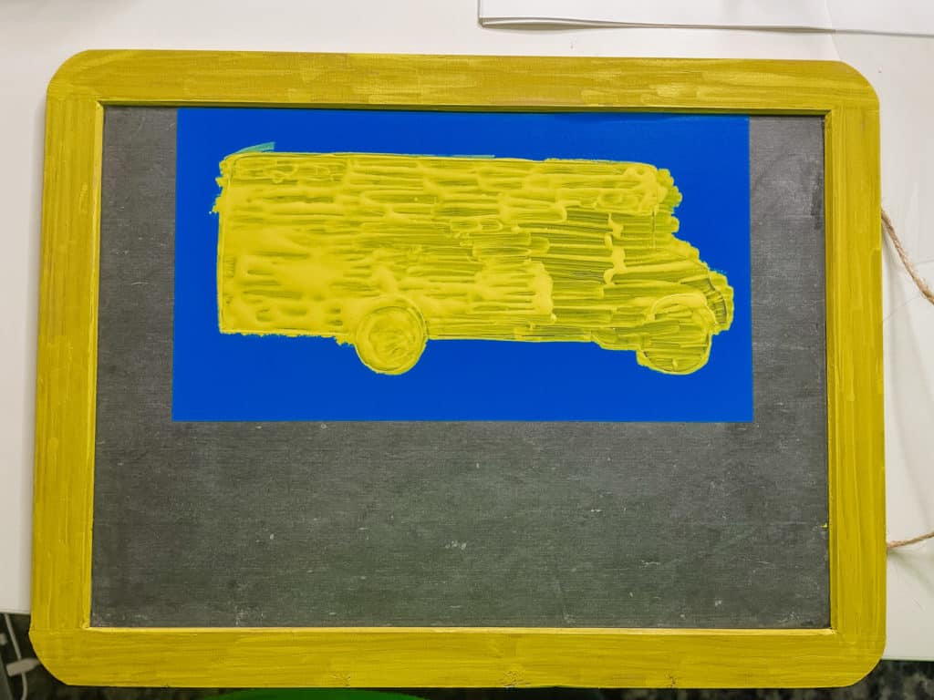 rectangle chalkboard with yellow frame. blue stencil with yellow bus on the inside.