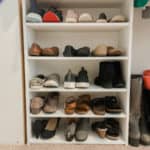 white shoe shelf with 5 shelves filled with shoes.