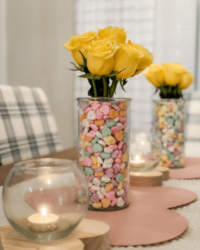 Easy Valentine's Decorations made with glass vases, pastel candy conversation hearts and yellow roses. 