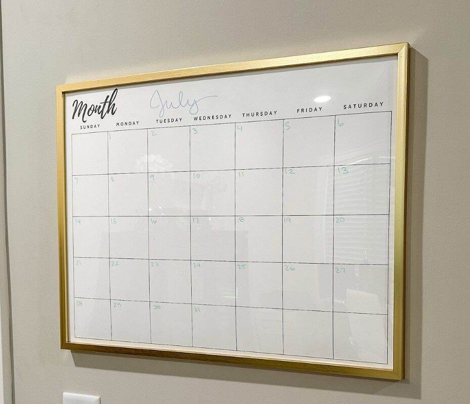 diy large wall calendar in gold frame hanging on grey wall