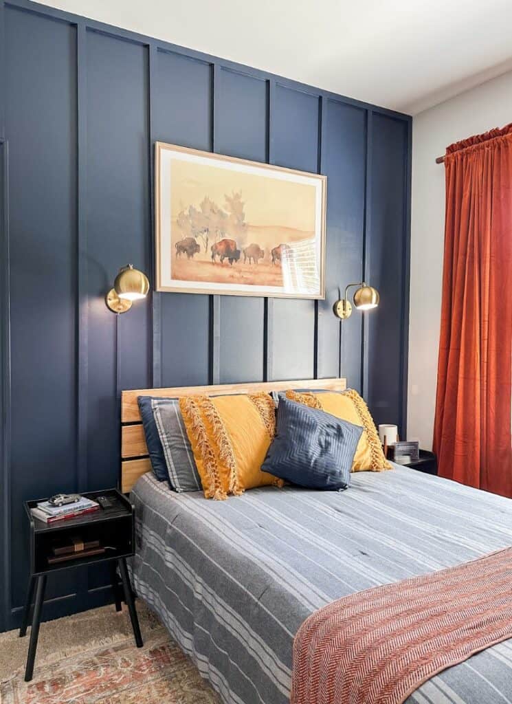 modern bedroom decor blue accent wall with large framed buffalo picture. full size bed with blue and white striped bedding with yellow accent pillows.