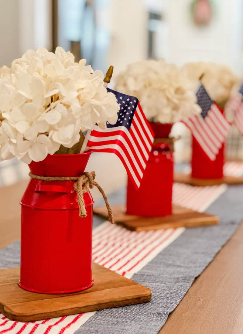 red jars with white hydrangeas and American flags. patriotic decor