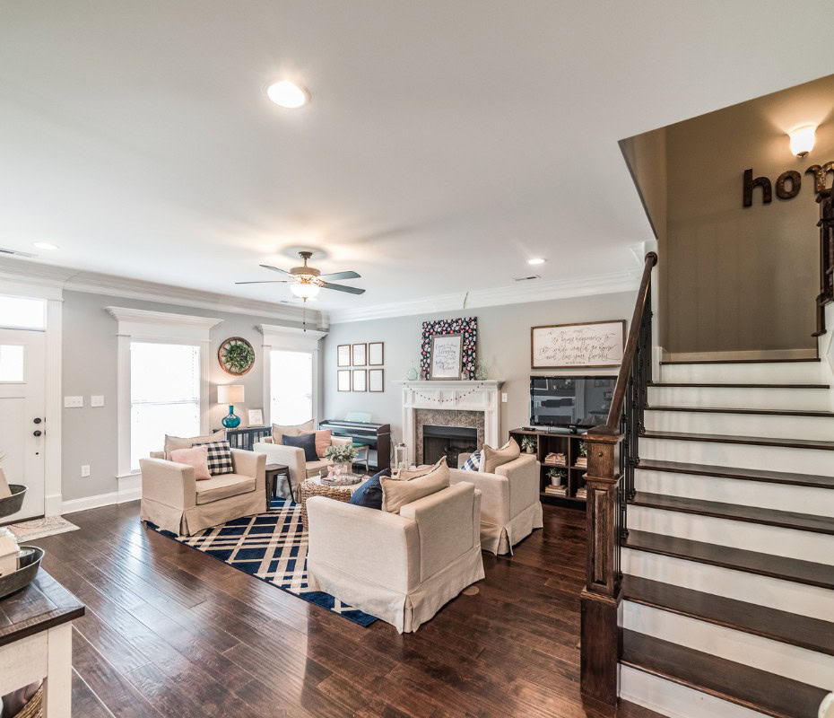 farmhouse sitting room decor. 4 white chairs on a navy plaid rug with hardwood floors underneath