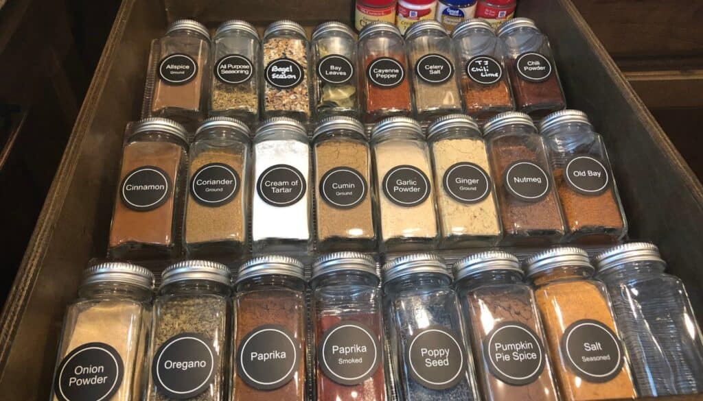 spice drawer organization square glass jars with silver lids and black circle labels